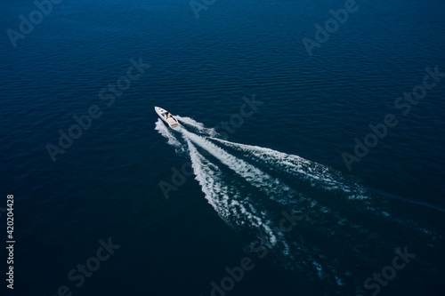 Aerial view luxury motor boat. Travel - image. Drone view of a boat  the blue clear waters. Drone view of a boat sailing. © Berg