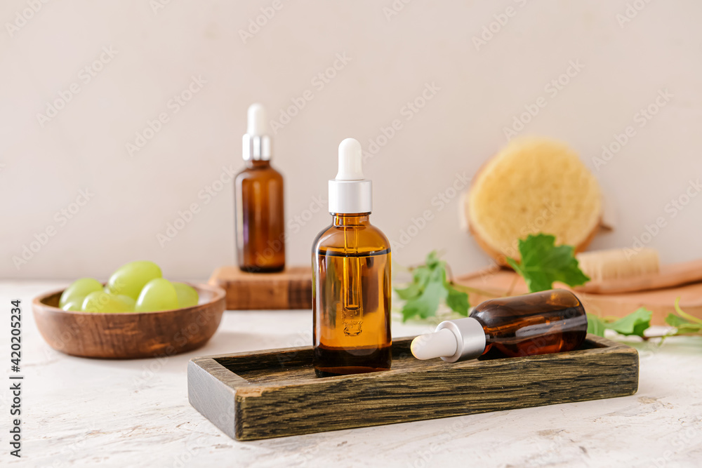 Bottles of grape seed oil on light background Bottles of grape seed oil on light background
