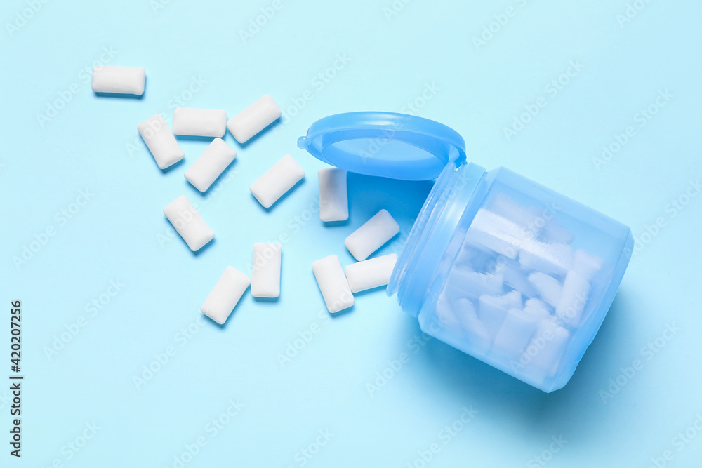Jar with tasty chewing gums on color background Jar with tasty chewing gums on color background