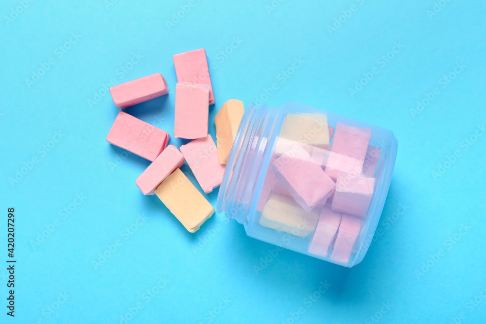 Jar with tasty chewing gums on color background Jar with tasty chewing gums on color background