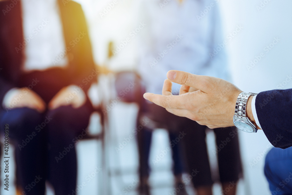 Business man making presentation to group of people in office. Speaker delivering a seminar to his colleagues. Teamwork and coaching concept Business man making presentation to group of people in office. Speaker delivering a seminar to his colleagues. Teamwork and coaching concept