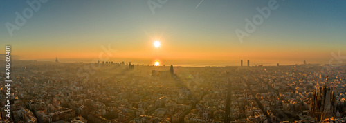 Panoramic aerial drone shot of Barcelona sea horizon in sunrise golden hour in foggy Spain winter