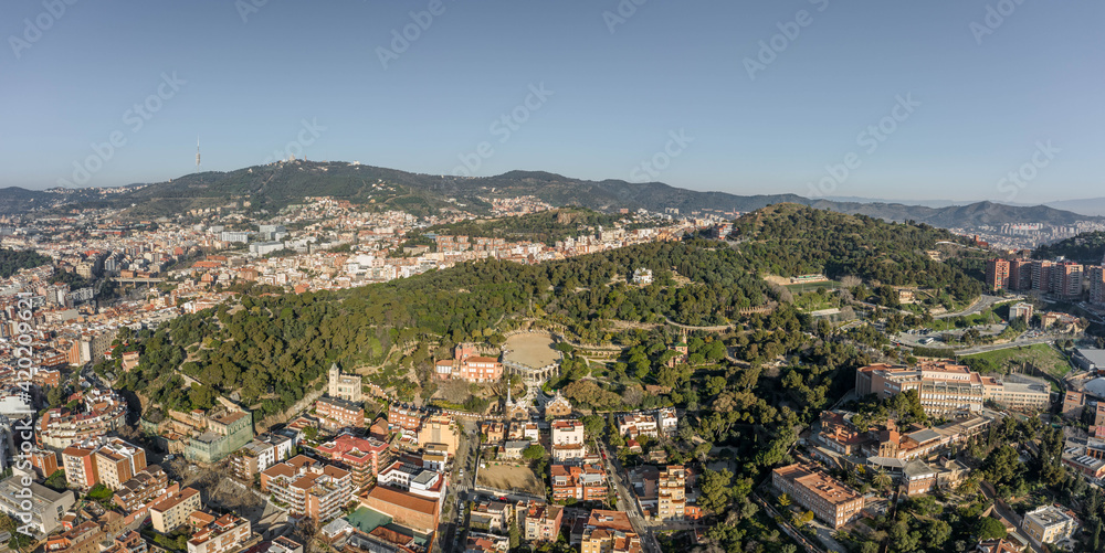 Aerial panorama drones shot of park on hill outside Barcelona city in Spain winter morning