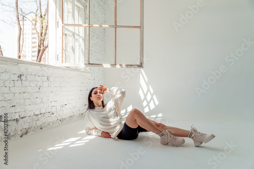 beautiful brunette girl in sportswear on a white background in a photo studio