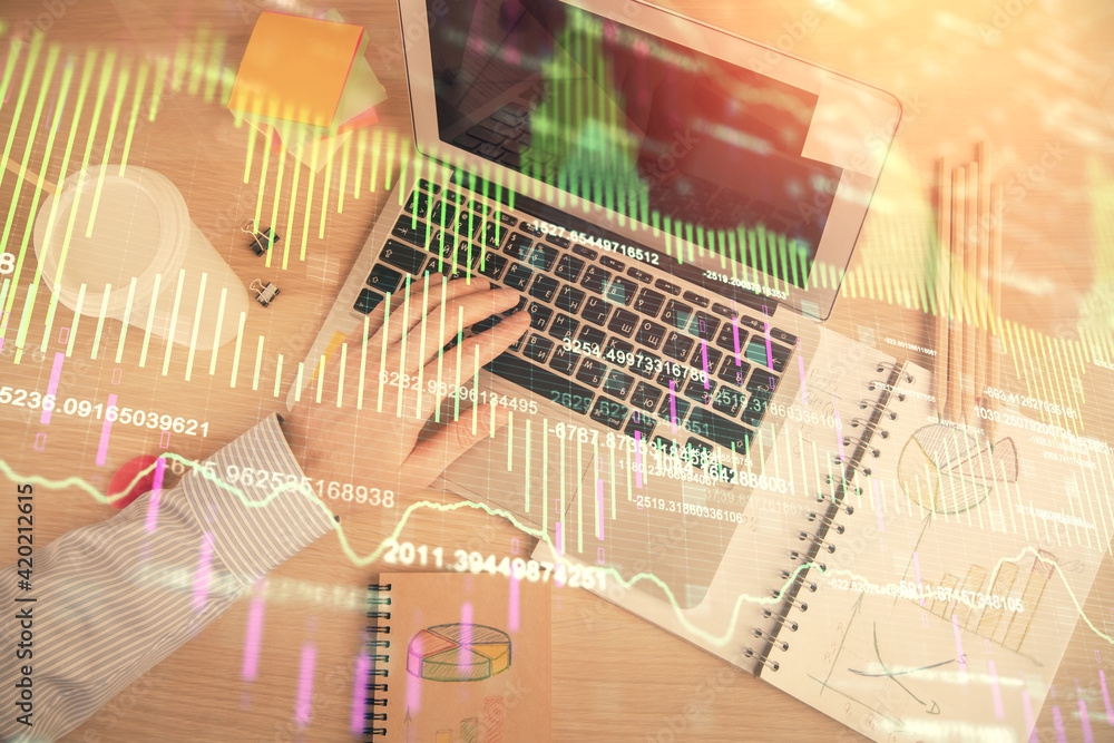 Double exposure of man's hands typing over computer keyboard and forex graph hologram drawing. Top view. Financial markets concept. Double exposure of man's hands typing over computer keyboard and forex graph hologram drawing. Top view. Financial markets concept.