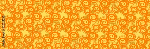 Orange spirals evenly spaced against a yellow background in a panoramic view