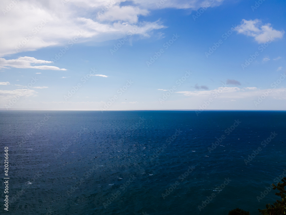 Genova, Italy - March 12, 2021 - Seascape, blue sky, clouds and sea in the tropical waters of the Mediterranean sea in winter days. Genova, Italy - March 12, 2021 - Seascape, blue sky, clouds and sea in the tropical waters of the Mediterranean sea in winter days.