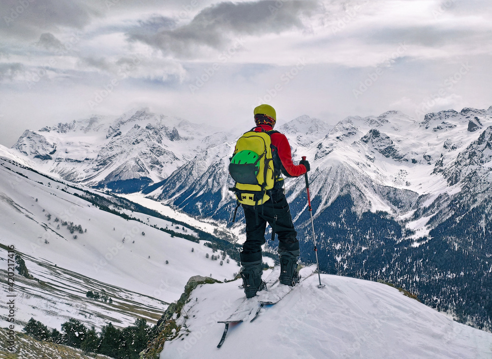 Sport man ski touring and standing at panoramic winter mountains background Sport man ski touring and standing at panoramic winter mountains background