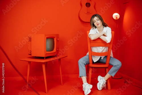 woman sitting on a chair. Isolation ina red cartoon room. High quality photo