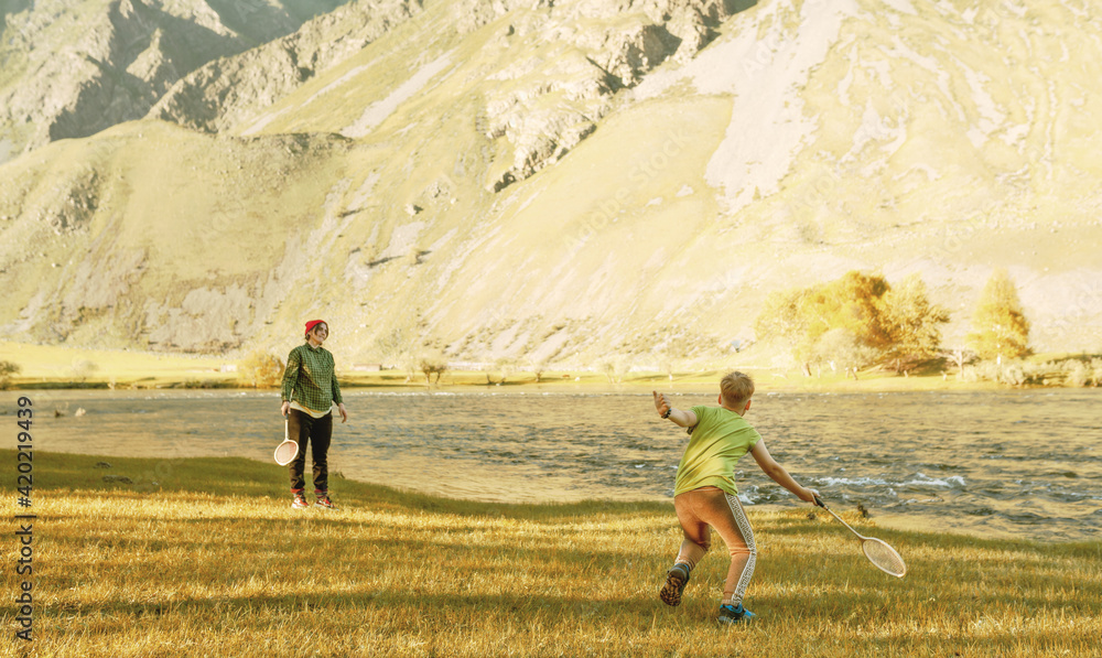 child and woman playing in badminton outdoors