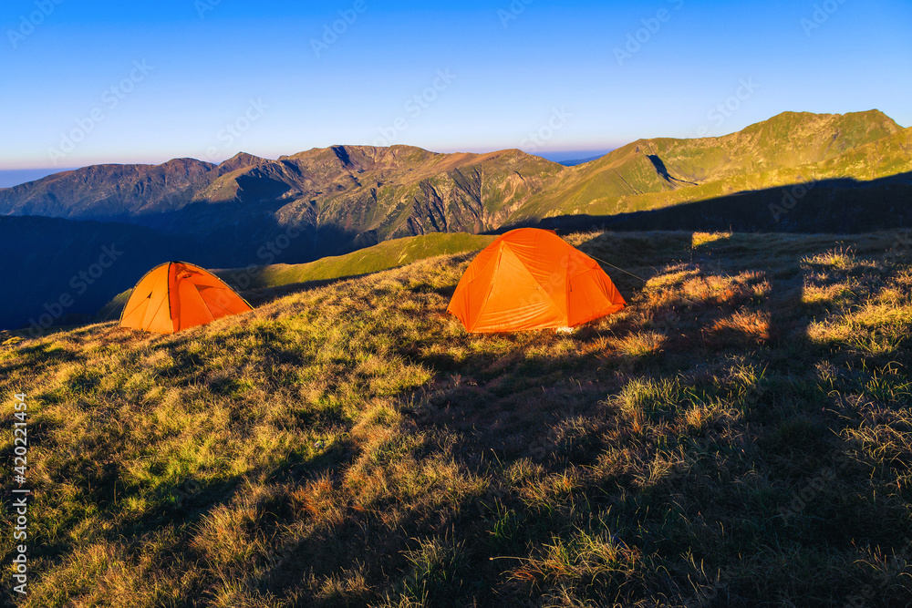 Wild camping place with colorful tents on the mountain ridge