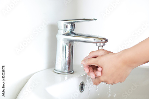 Washing and Rubbing hands on sink with silver tap water