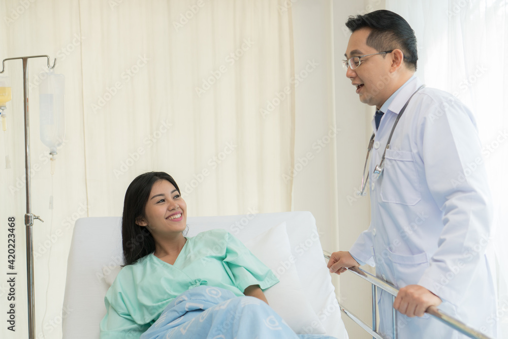 cheerful Asian doctor talking with young woman patient for monitoring and check up after surgery. doctor giving advice in the touchscreen to women to take care the lesion after out of hospital. cheerful Asian doctor talking with young woman patient for monitoring and check up after surgery. doctor giving advice in the touchscreen to women to take care the lesion after out of hospital.