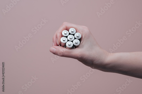 Hand holding alkaline batteries. Energy and power supply concept with copy space