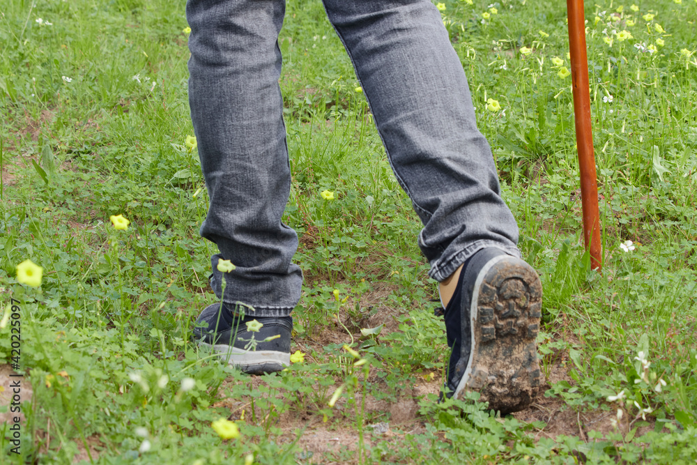 Feet of an adult man walking wearing hiking boots. Travel and trekking concept Feet of an adult man walking wearing hiking boots. Travel and trekking concept