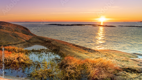 Sunset on skerries in Ytre Hvaler National Park, on the island of Kirkeoy in Norway photo