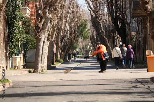 A municipal employee cleaning on a magnificent tree-designed street in Buyukada, Istanbul
