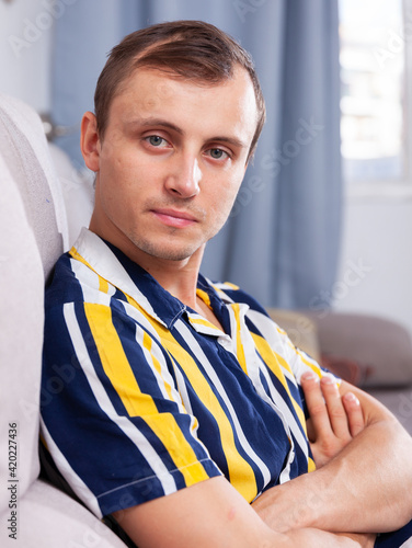 Attractive young man in a striped shirt at home photo