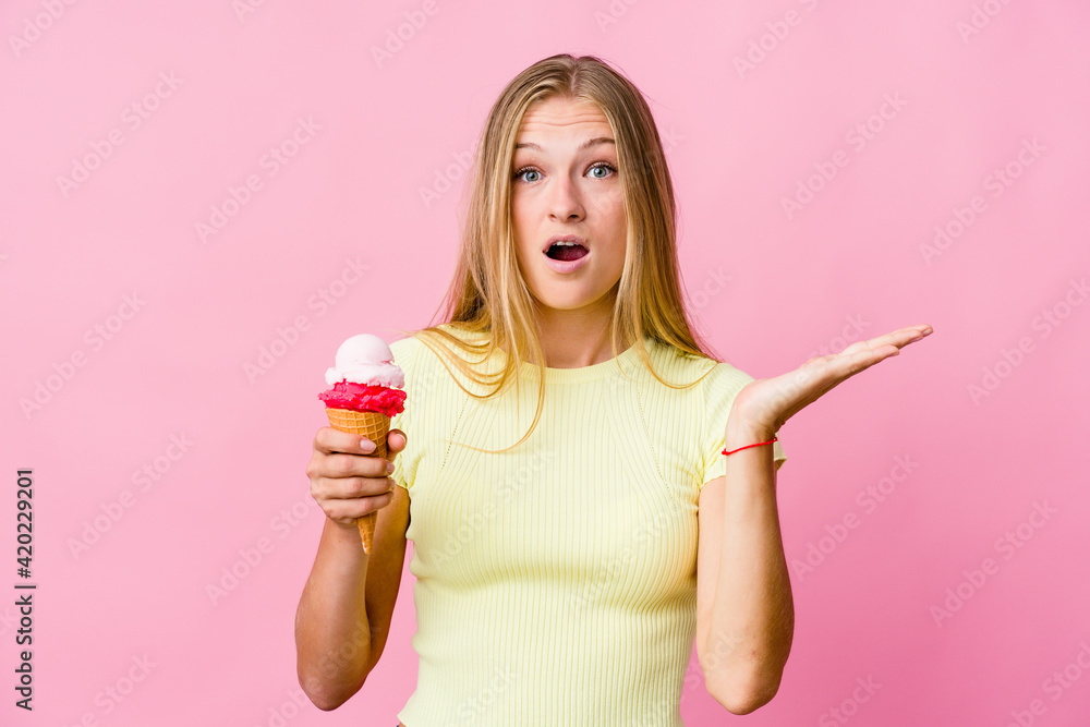 Young russian woman eating an ice cream isolated surprised and shocked. Young russian woman eating an ice cream isolated surprised and shocked.