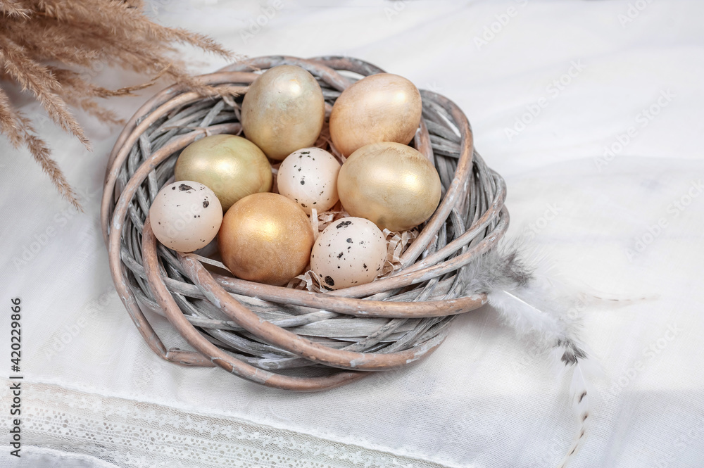 composition of eggs in a nest and feathers on a light background composition of eggs in a nest and feathers on a light background