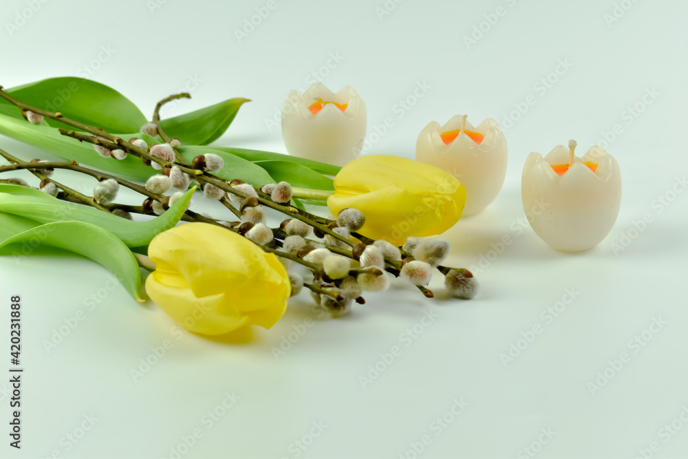 Fototapeta premium Żółte tulipany, jajka, świeczki i ozdoby Wielkanocne.