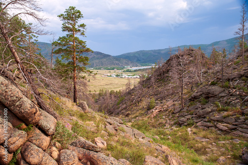 A small town in the valley amongst rocky terrain and some woodland in the Bayanaul National Park, Kazakh Uplands.