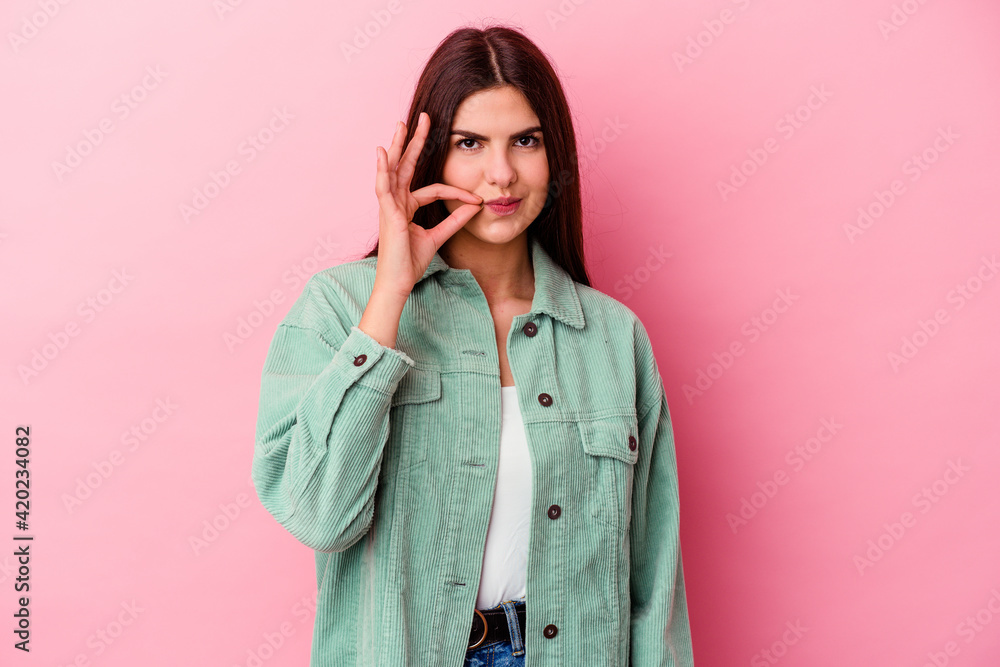 Young caucasian woman isolated on pink background with fingers on lips keeping a secret. Young caucasian woman isolated on pink background with fingers on lips keeping a secret.