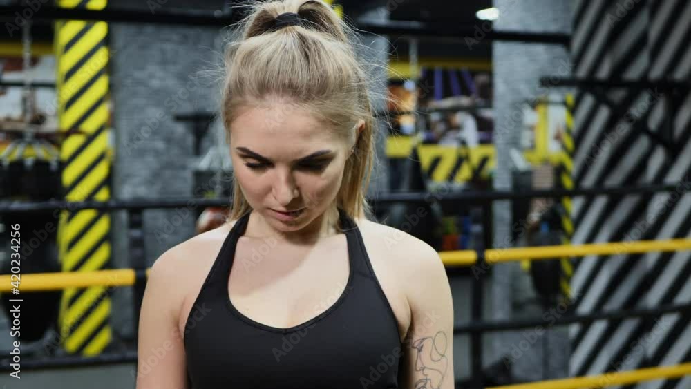 A young athletic boxer girl looks into the camera and prepares for a punch.