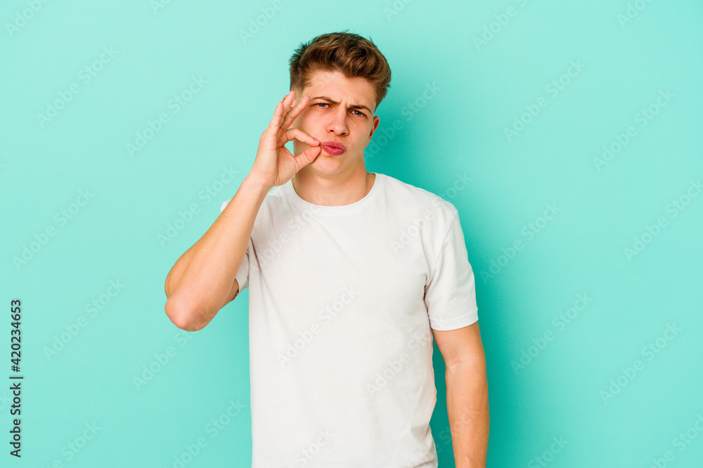 Young caucasian man isolated on blue background with fingers on lips keeping a secret. Young caucasian man isolated on blue background with fingers on lips keeping a secret.