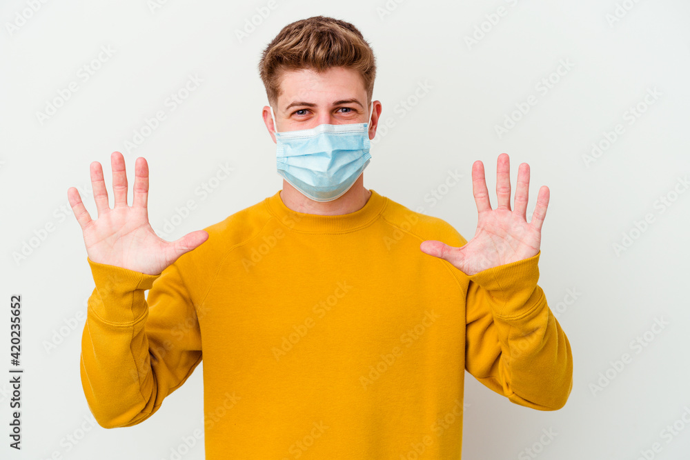 Young man wearing a mask for coronavirus isolated on white background showing number ten with hands. Young man wearing a mask for coronavirus isolated on white background showing number ten with hands.