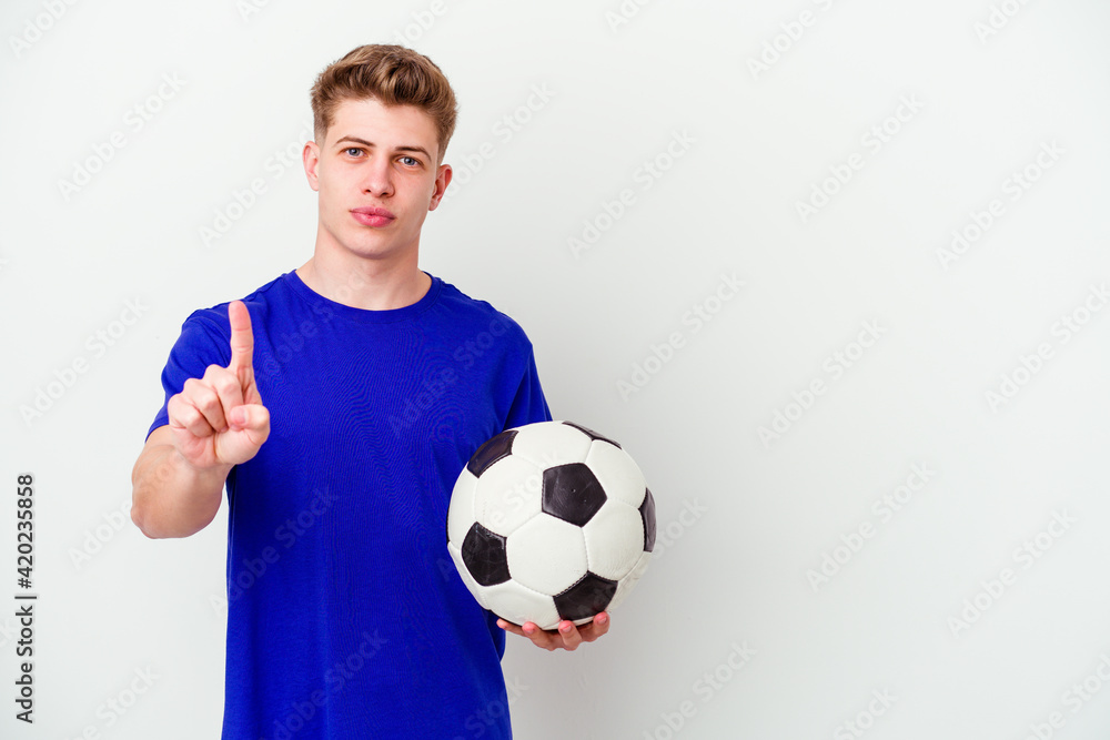 Young caucasian man playing soccer isolated on background showing number one with finger.