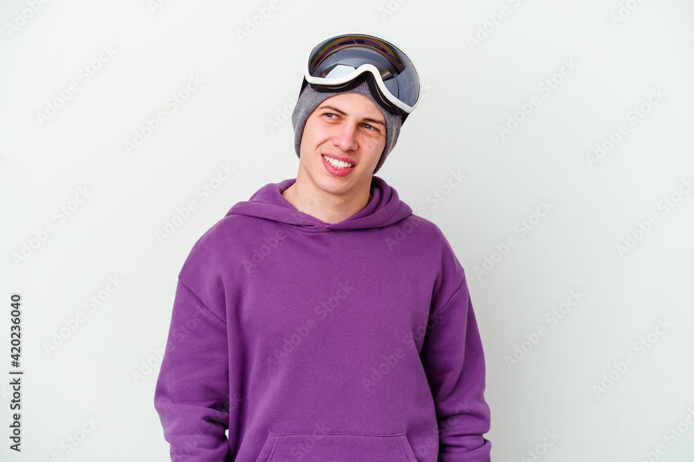 Young man holding a snowboard board isolated on white background looks aside smiling, cheerful and pleasant. Young man holding a snowboard board isolated on white background looks aside smiling, cheerful and pleasant.