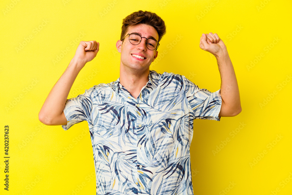 Young caucasian man isolated on yellow background celebrating a special day, jumps and raise arms with energy. Young caucasian man isolated on yellow background celebrating a special day, jumps and raise arms with energy.