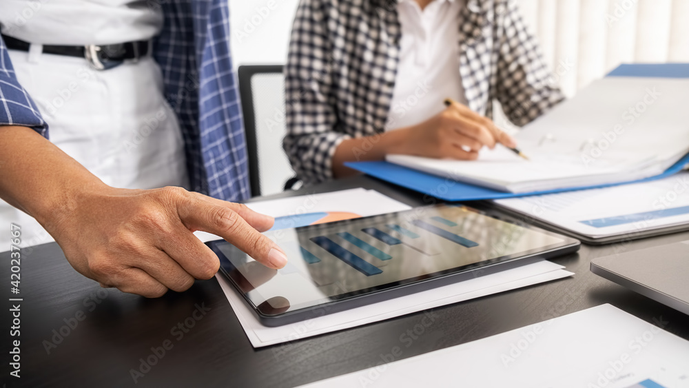 Business woman using tablet to checking the company performance chart in the office. Business concept. Business woman using tablet to checking the company performance chart in the office. Business concept.