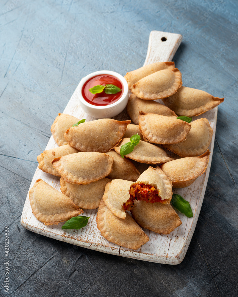 Margarita Margherita pizza parcels pockets filled with tomato, mozzarella cheese and basil served on white wooden board. Party finger food