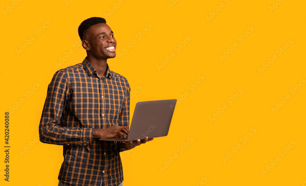 Online Education Programs. Black millennial guy with laptop in hands, yellow background Online Education Programs. Black millennial guy with laptop in hands, yellow background