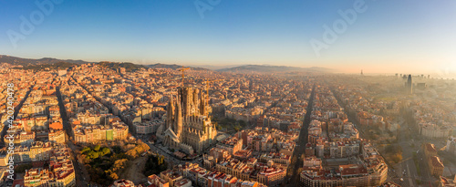 Aerial panorama drone shot of Barcelona center and coast in foggy morning golden hour in Spain winter