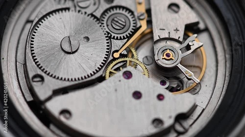 Internal working mechanism of the wristwatch with a rapidly rotating pendulum and gears. 4k clock close up with shallow depth of field