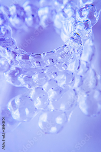 Invisible aligner teeth retainers on a blue background © johnalexandr