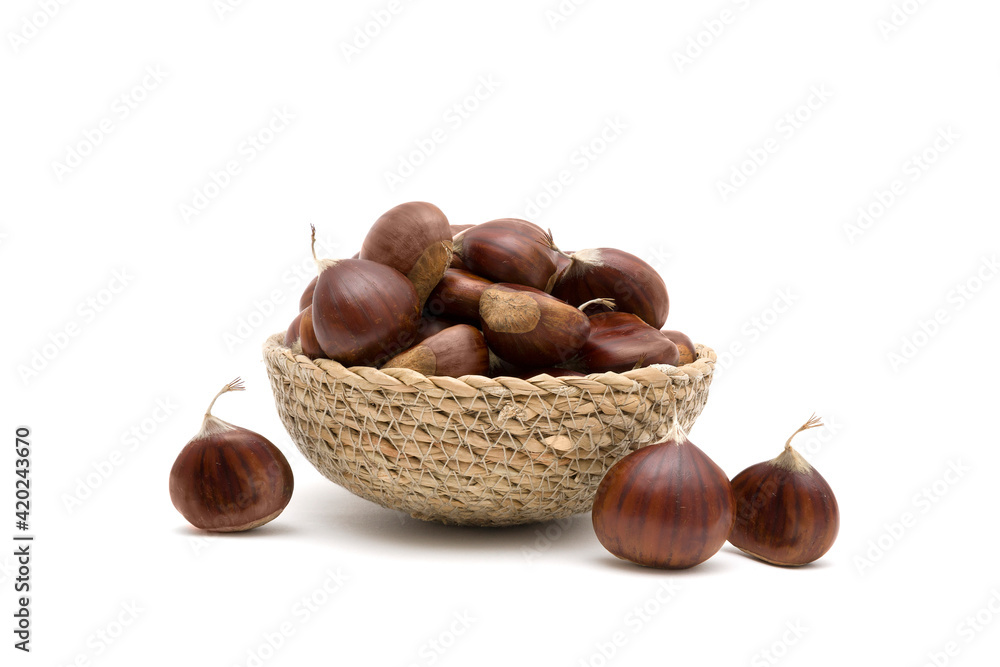 Obraz premium Fresh raw sweet chestnuts(Castanea sativa) in a wicker basket isolated on a white background
