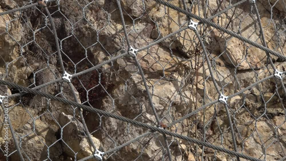 installation of active rockfall barrier system is covering the mountain to prevent stones from falling down