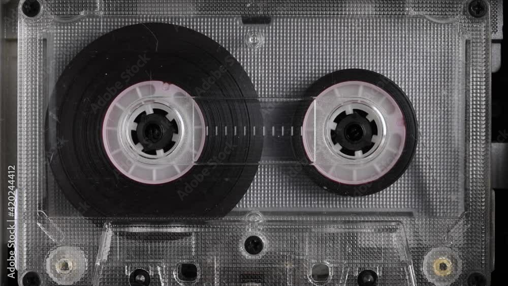 Close-up A tape recorder is playing an audio cassette. Close-up. A vintage audio cassette spins on a blank label tape used to record sound in a retro cassette player. Recording of conversations.