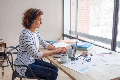 Empty space for text. A woman of 40-45 years old works in the office.