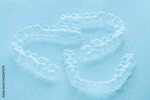 Invisible aligner teeth retainers on a blue background