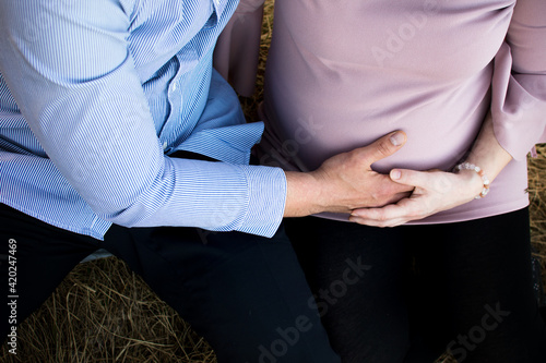 Close up of a couple holding their hands on pregnancy belly