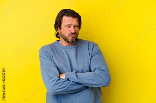 Middle age caucasian man isolated on yellow background unhappy looking in camera with sarcastic expression.