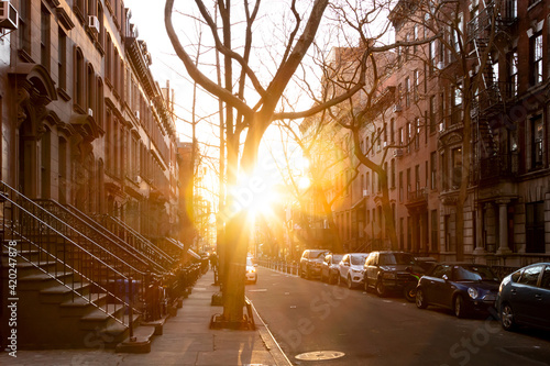 Konstfotografi Sunlight shines on a block of historic brownstone buildings on Perry Street in t