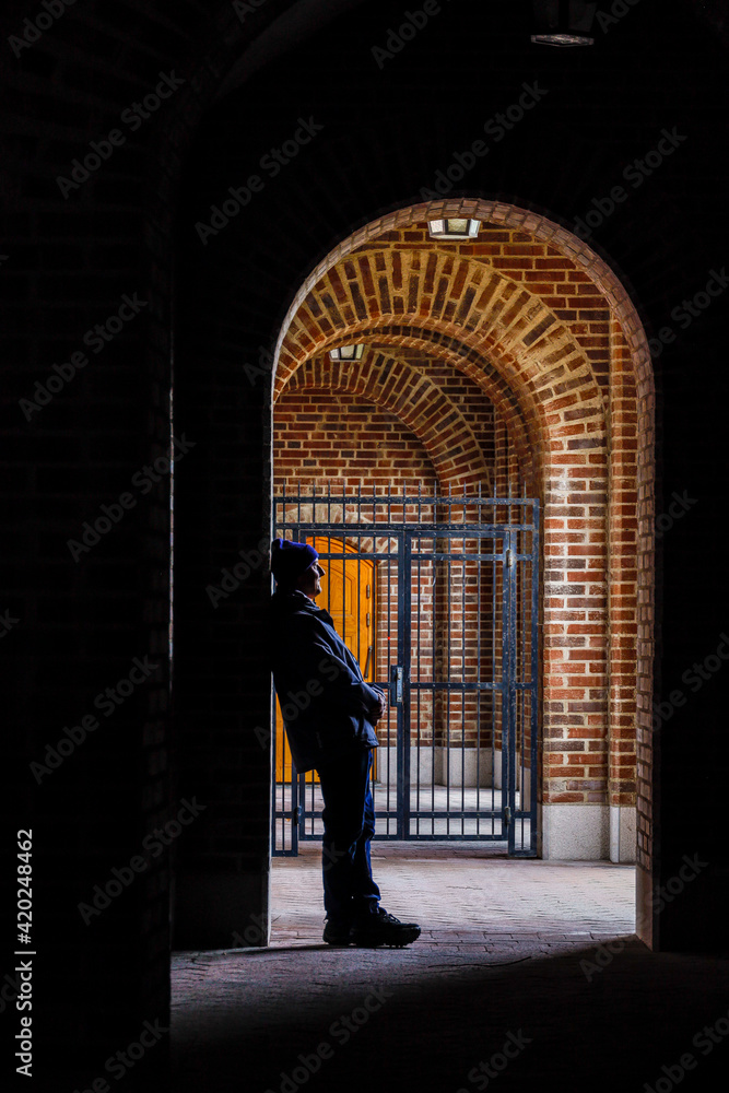 Stockholm, Sweden A man leans against an archway in an outdoor corridor at the Stockholm Stadion Olympic stadium.