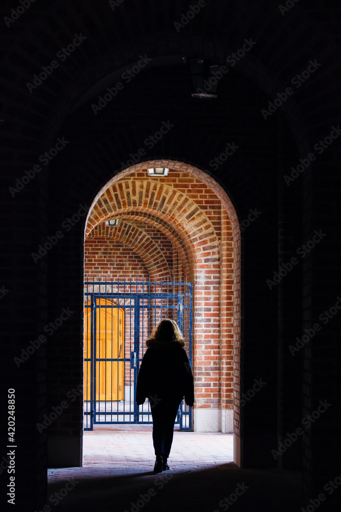 Stockholm, Sweden A woman walks under an archway in an outdoor corridor at the Stockholm Stadion Olympic stadium.