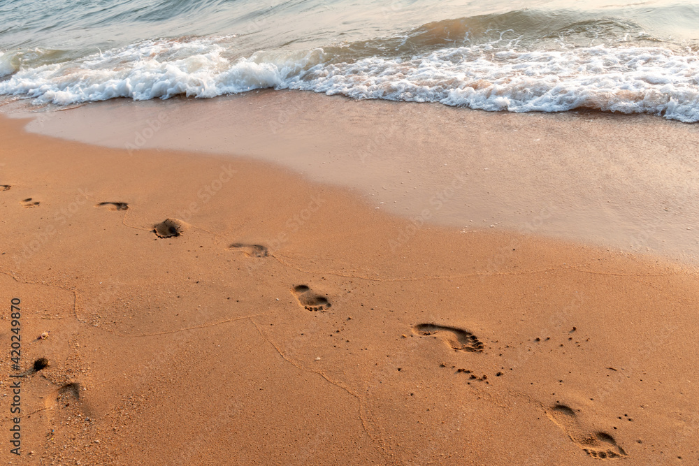 Human footsteps on the beach with sea wave Human footsteps on the beach with sea wave